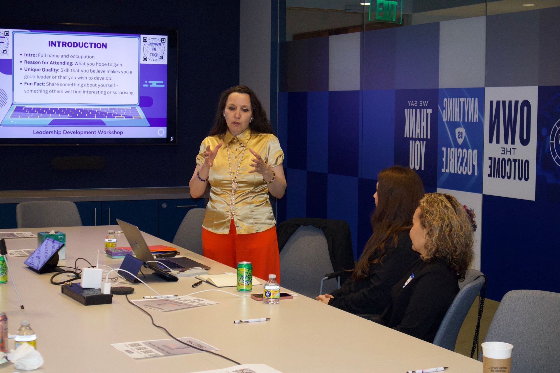 Woman presenting during a leadership development workshop with participants seated at a table.